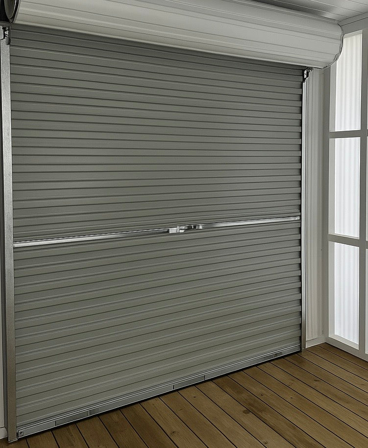 Roll-up garage door in a room with wooden floor and window